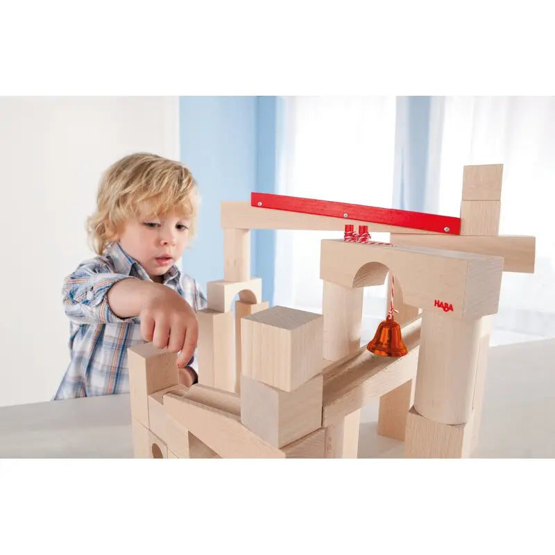 Kind spielt mit der HABA Murmelspaß XXL Kugelbahn aus Holz und baut eigene Bahn-Layouts