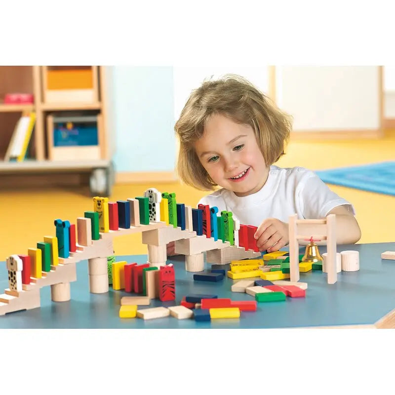 Kind baut einen Domino-Parcours mit HABA Purzelklötze Holzzubehör