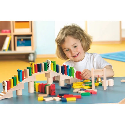Kind baut einen Domino-Parcours mit HABA Purzelklötze Holzzubehör